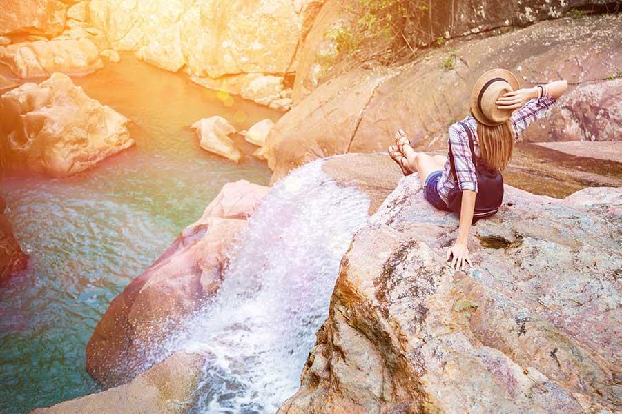 Woman on a rock with a waterfall in Vietnam