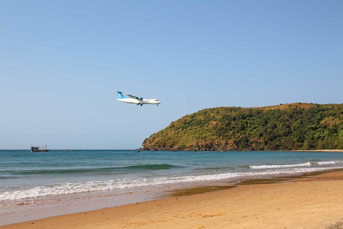An airplane is landing close to the beach