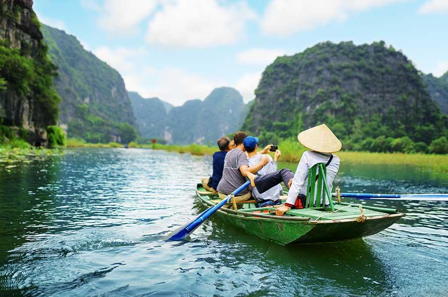 Tourists take pictures on a boat in a river
