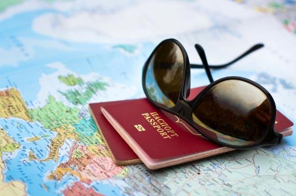 Two passports and sunglasses lay on a map of Europe